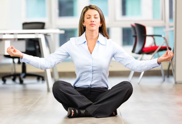 Business woman doing yoga at the office