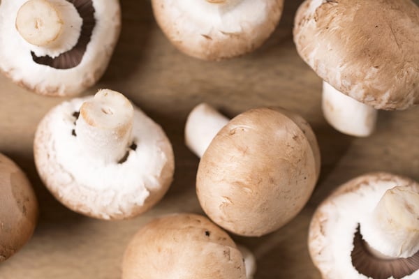 Selection of fresh raw mushrooms on a wooden kitchen work surface