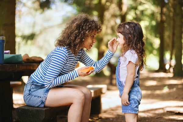 woman and child applying sunscreen