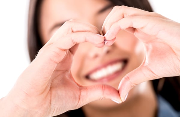Woman making a heart shape with her hands - isolated over white